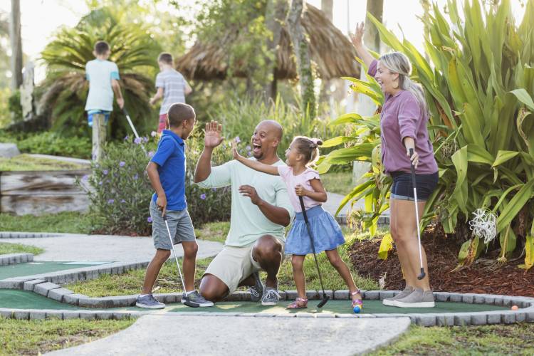 Family playing mini golf